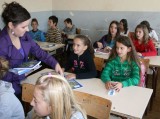 Vedoucí programu Participace, koordinátorka Národního parlamentu dětí a mládeže Jana Votavová rozdává šajkovackým žákům učební pomůcky.